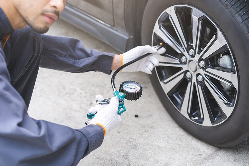 service expert checking tire pressure